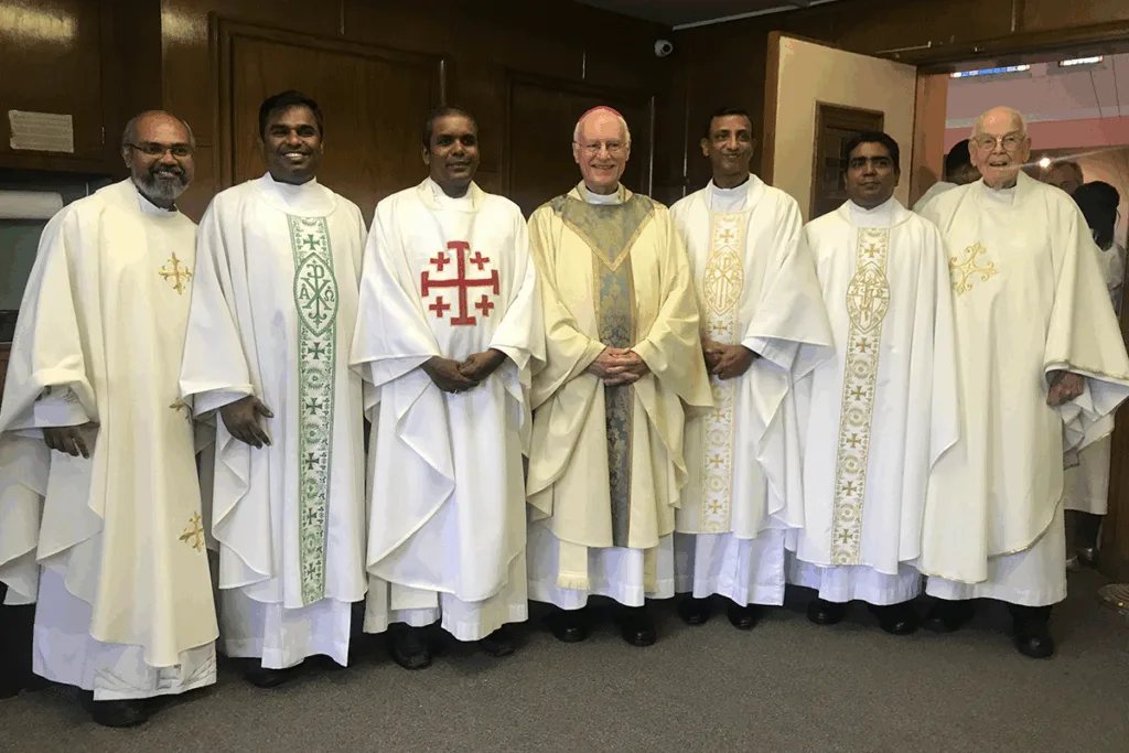 Priests and seminarians together with a bishop in liturgical vestments